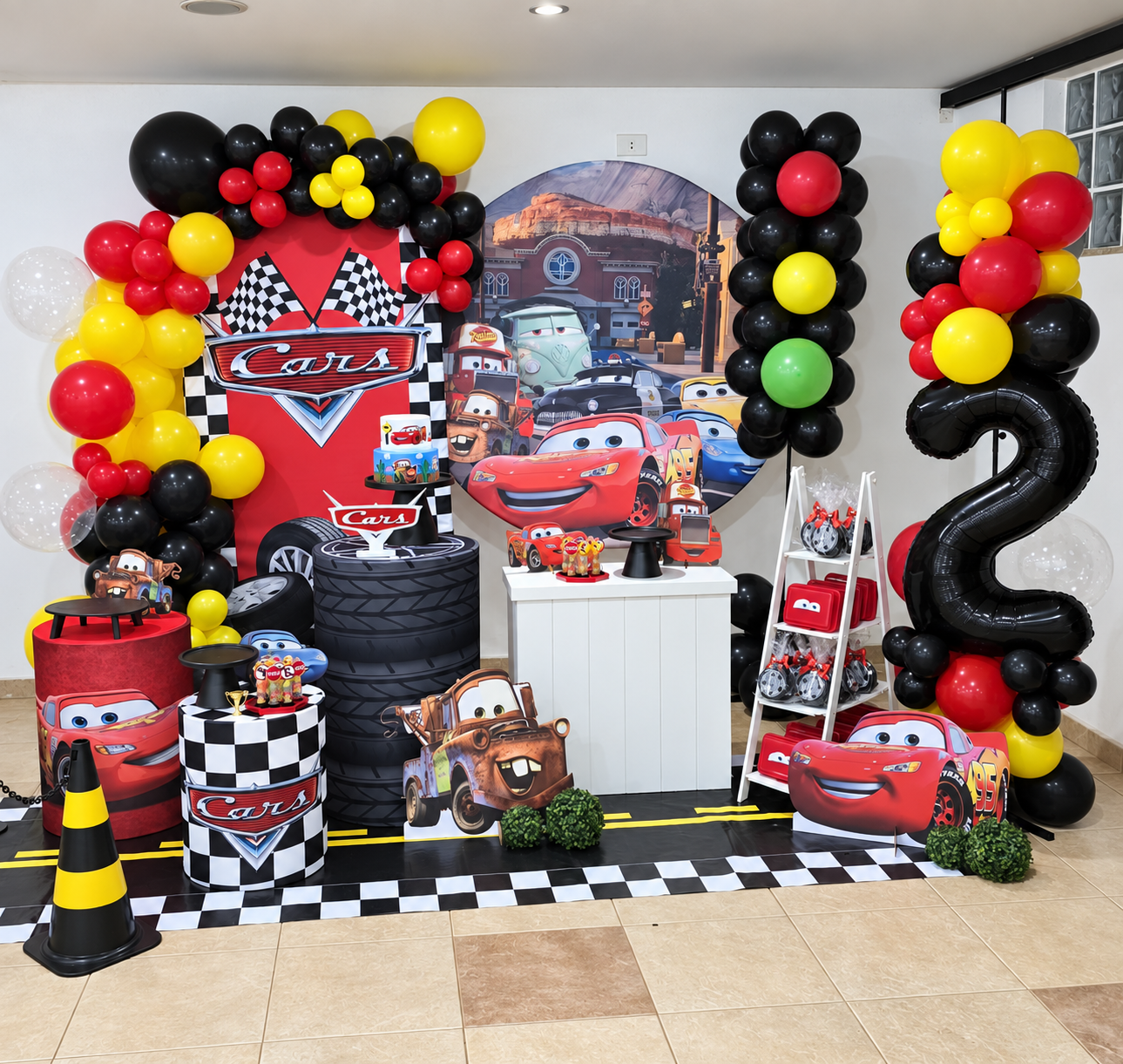Decoração completa temática de carros com painéis, mesas e arco de balões